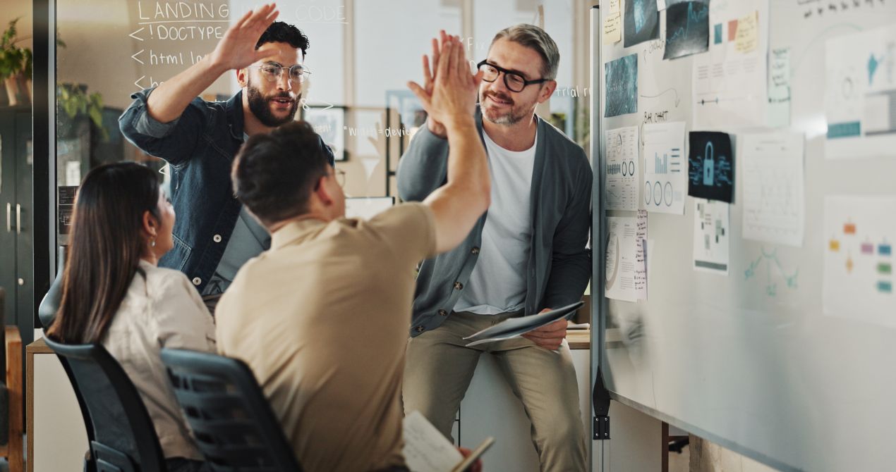 Teammeeting mit Whiteboard und IT-Sicherheitsdiagrammen – Entwicklung einer effektiven IT-Security-Strategie für Startups und Unternehmen.