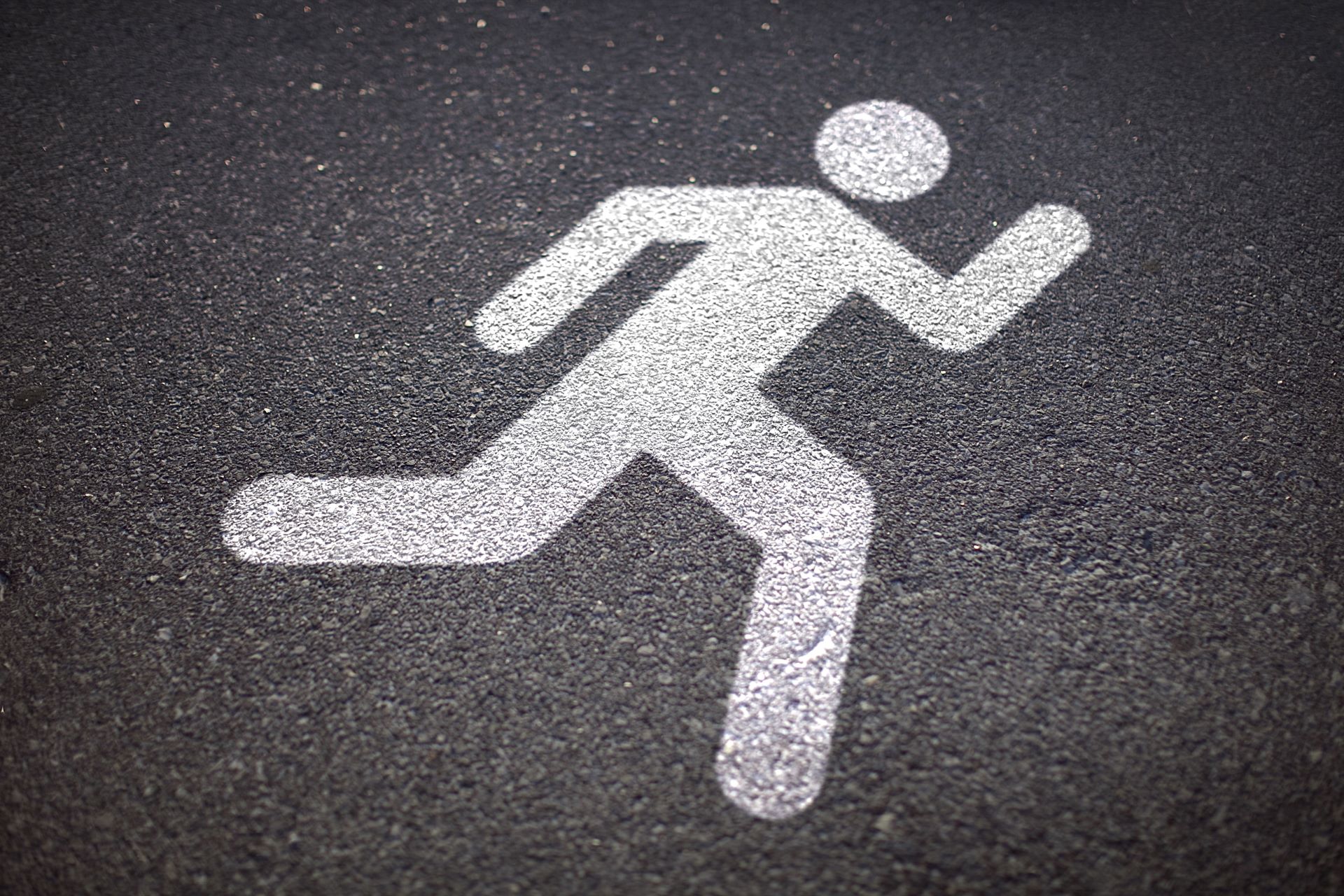 Laufweg-Symbol für Fluchtweg auf Asphalt markiert