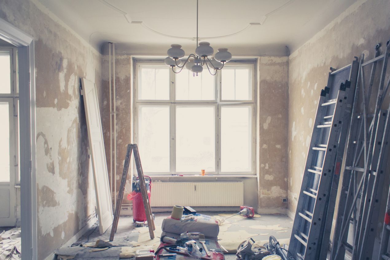 Innenraum einer unsanierten Altbauwohnung mit Leitern, Werkzeugen und Bauschutt – typische Szene waehrend einer wohnungssanierung berlin