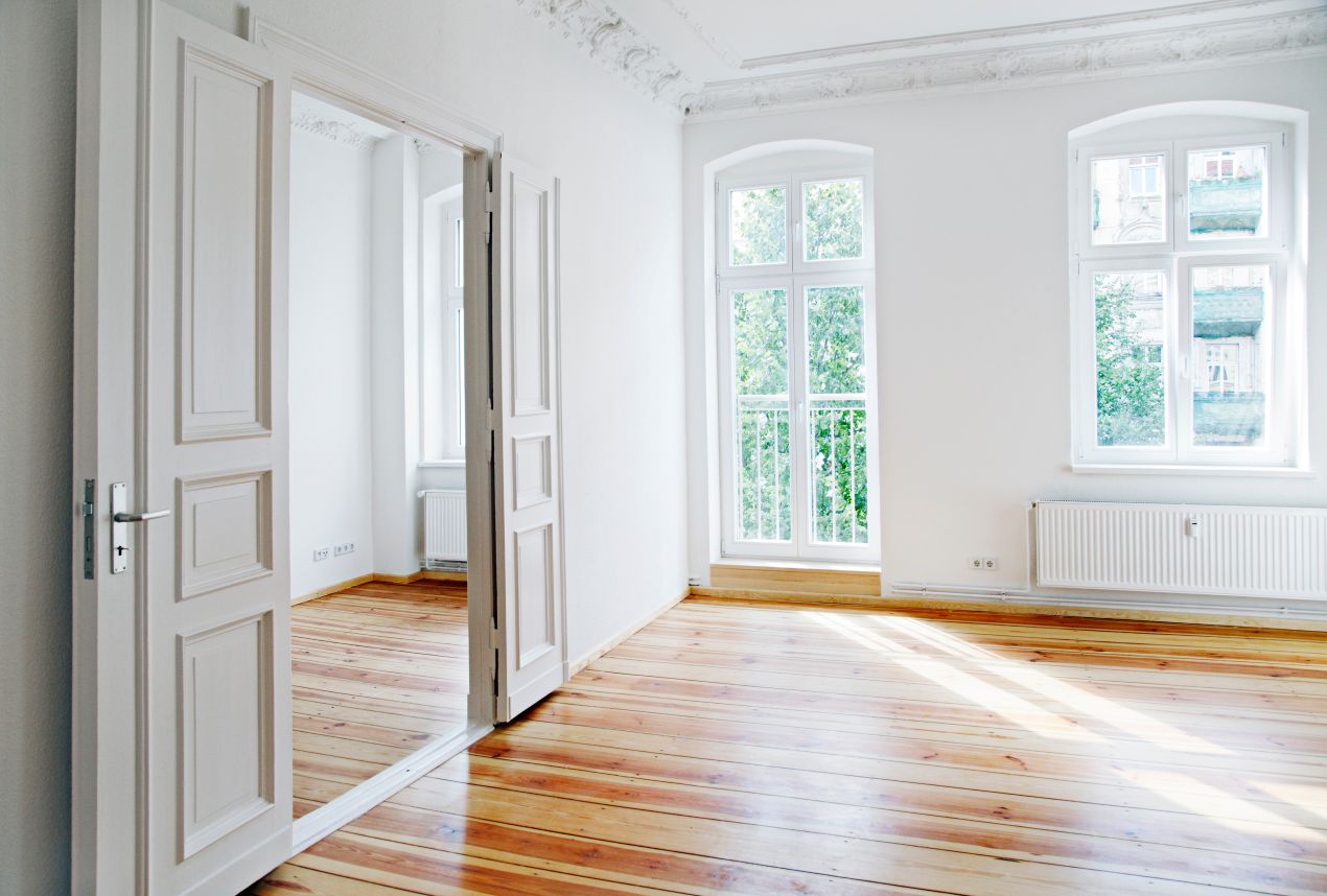 Heller Altbau-Innenraum mit Dielenboden, Stuck und neuen Fenstern nach erfolgreicher wohnungssanierung berlin