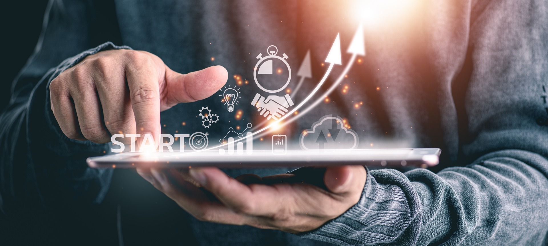 Finger tippt auf Tablet mit Symbolen für Startup und Erfolg | Stehtisch